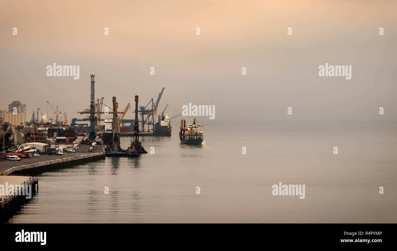 Il porto di Lisbona su un nebbioso giorno con i loro contenitori di gru, Portogallo. Foto Stock