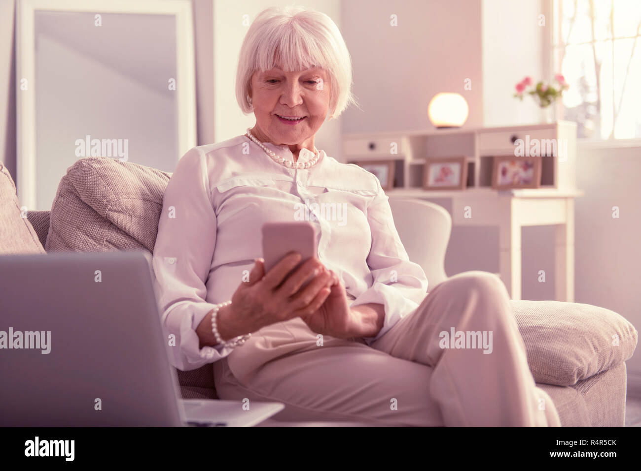 Bella donna più anziano di monitoraggio con entusiasmo il suo telefono Foto Stock