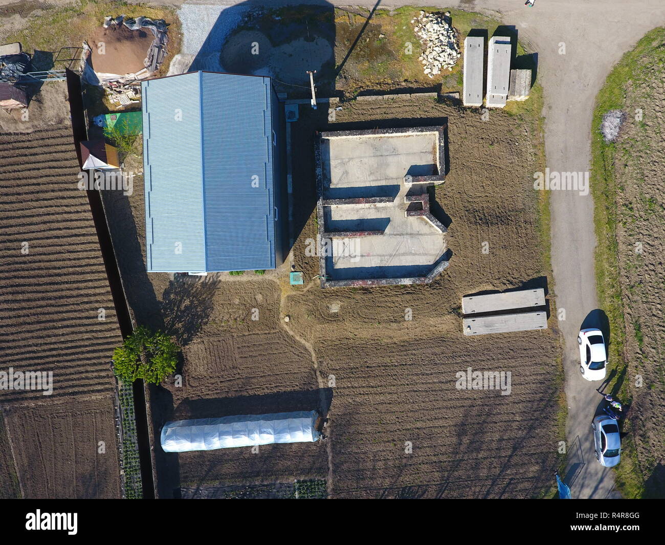 Immobili sul sito. Hangar da profilo metallico ondulati. La fondazione della casa. Foto Stock