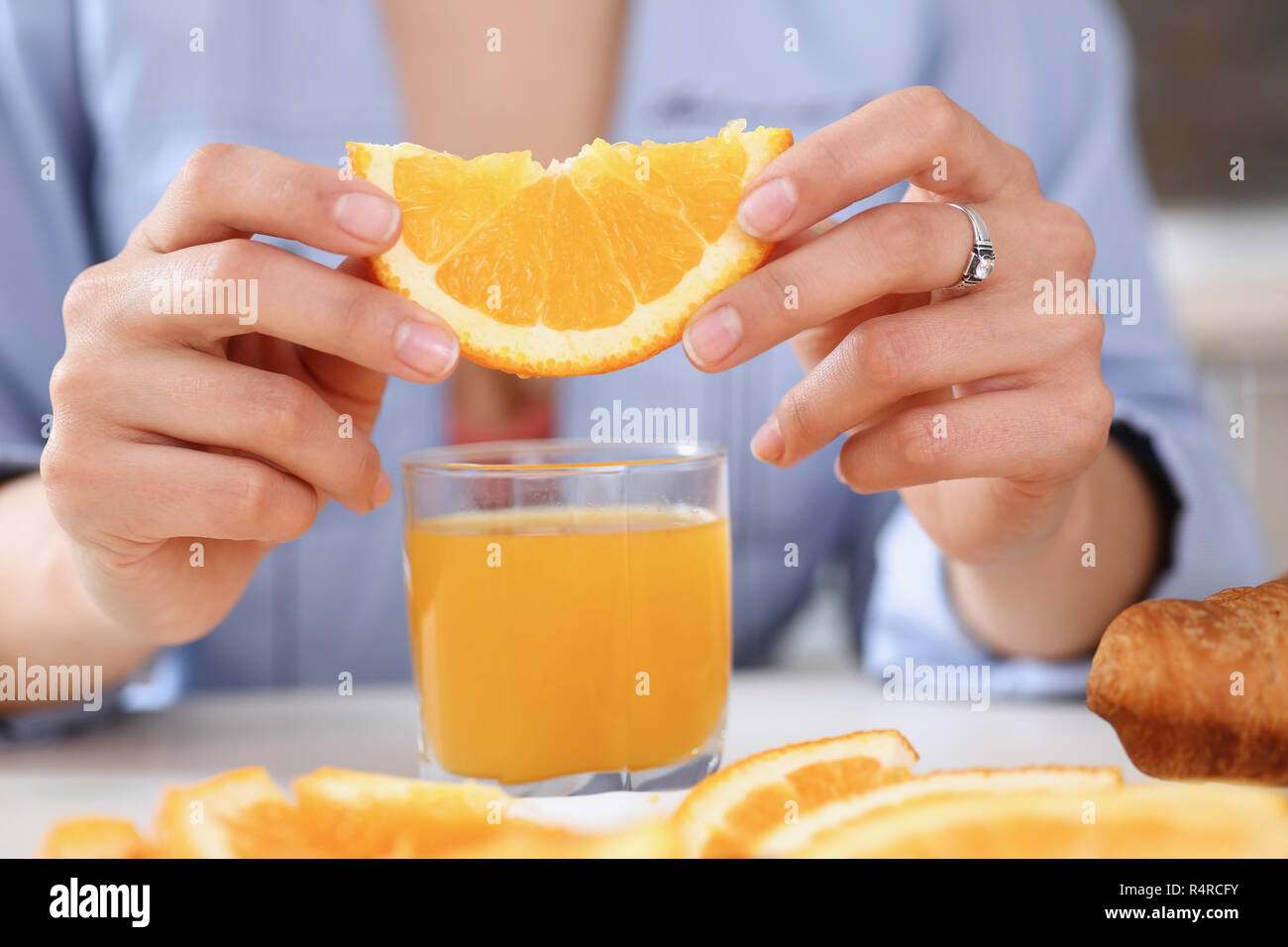 Bracci femmina tenere scorre arancione e il bicchiere di succo di frutta Foto Stock