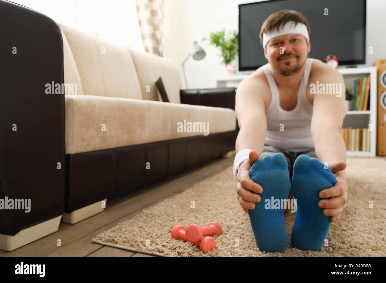 Giovani attraenti uomo fitness giace su un tappeto di grasso con Foto Stock
