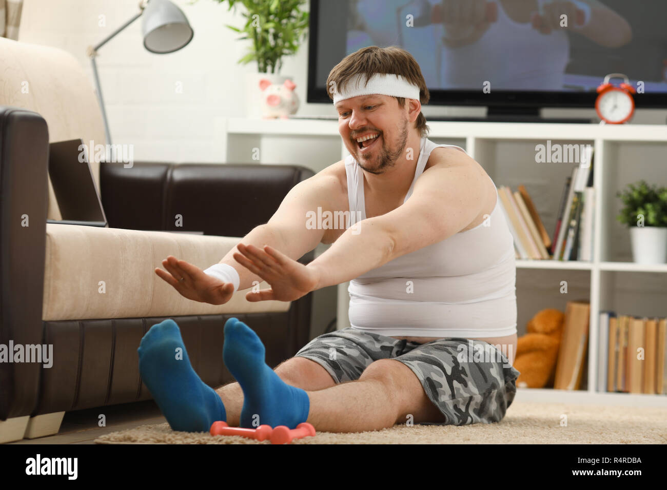 Giovani attraenti uomo fitness giace su un tappeto di grasso con Foto Stock