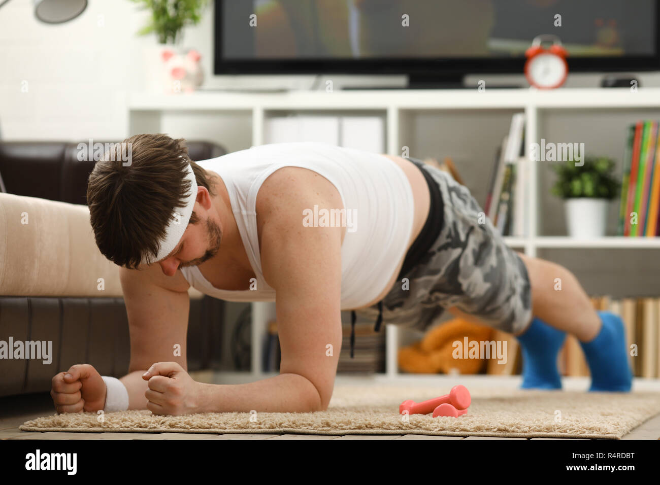Giovani attraenti uomo fitness giace su un tappeto di grasso con Foto Stock