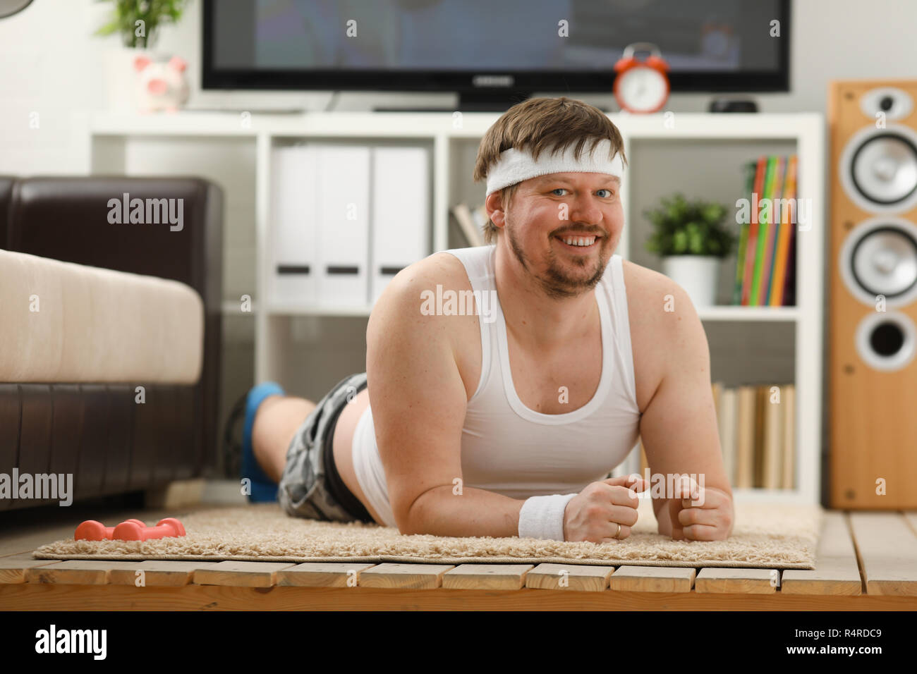 Giovani attraenti uomo fitness giace su un tappeto di grasso con Foto Stock