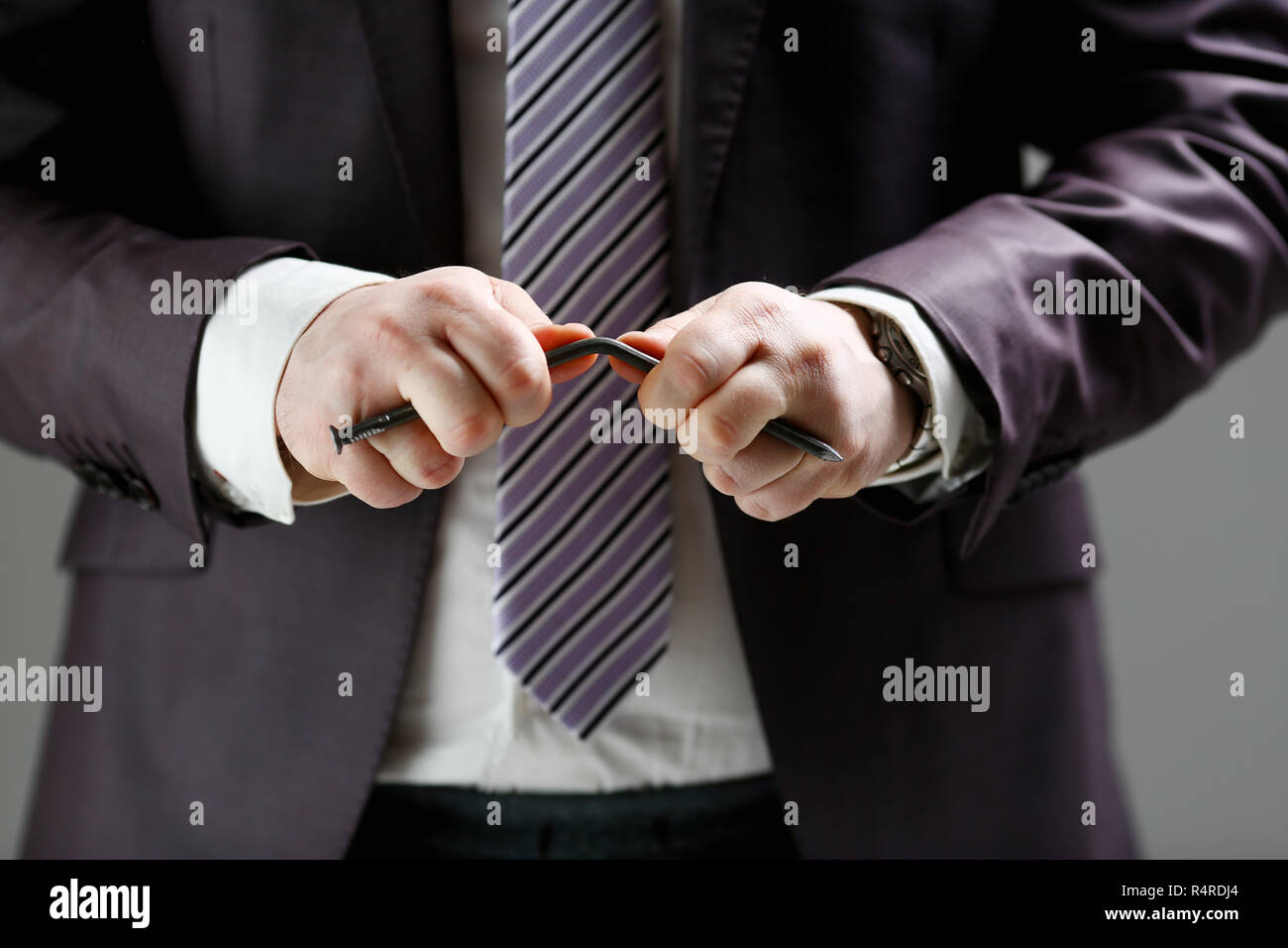 Uomo in tuta e cravatta piegare chiodo con bracci closeup Foto stock - Alamy