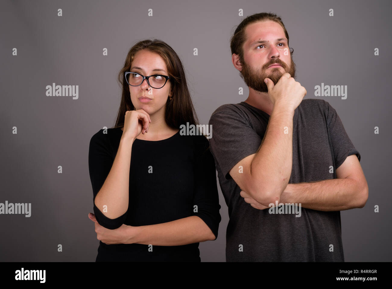 Ritratto di coppia giovane pensando contro uno sfondo grigio Foto Stock