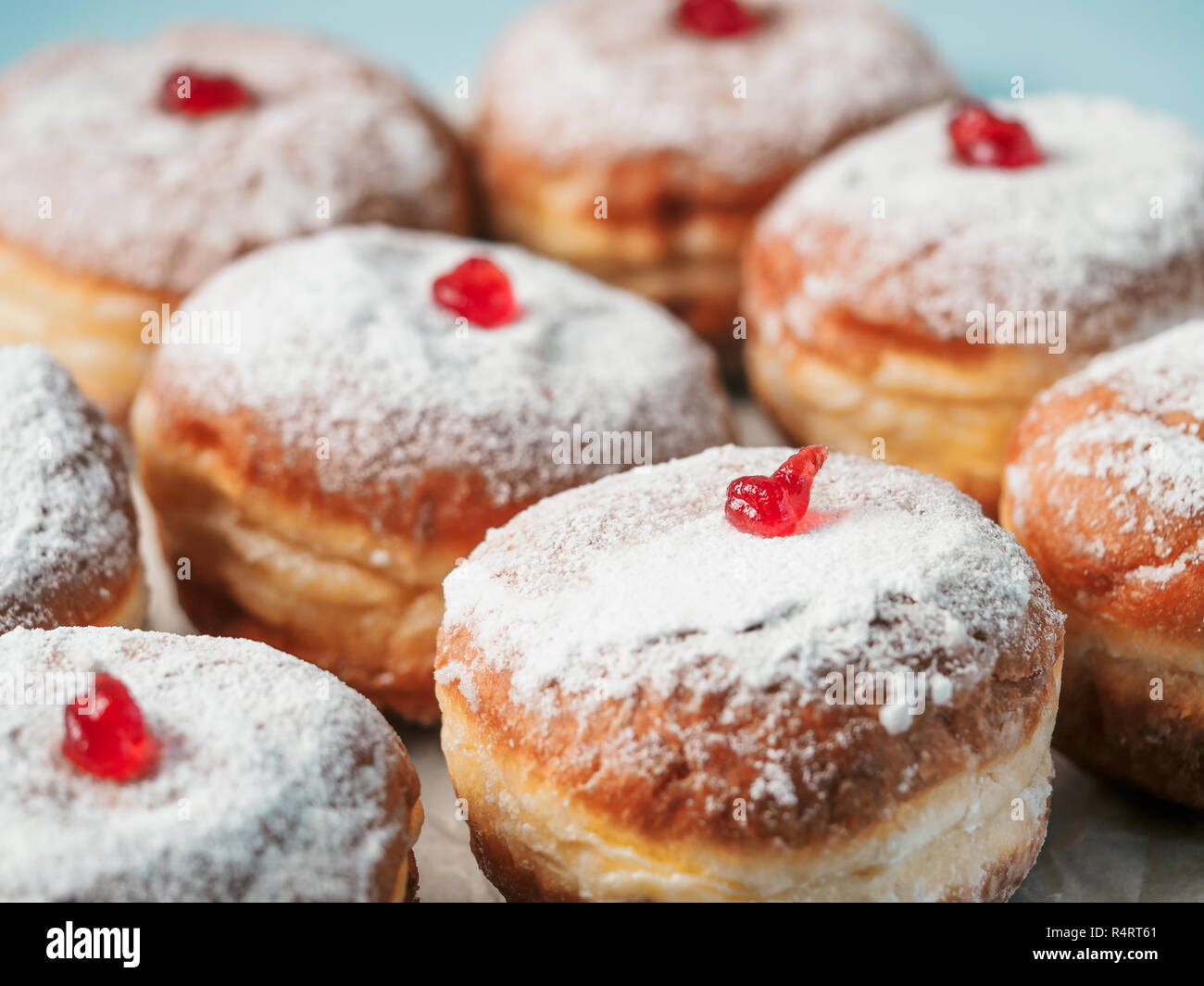 Hanukkah cibo ciambelle con marmellata e zucchero in polvere su sfondo blu. Festa ebraica Hanukkah concetto e lo sfondo. Copia spazio per il testo. DOF poco profondo Foto Stock