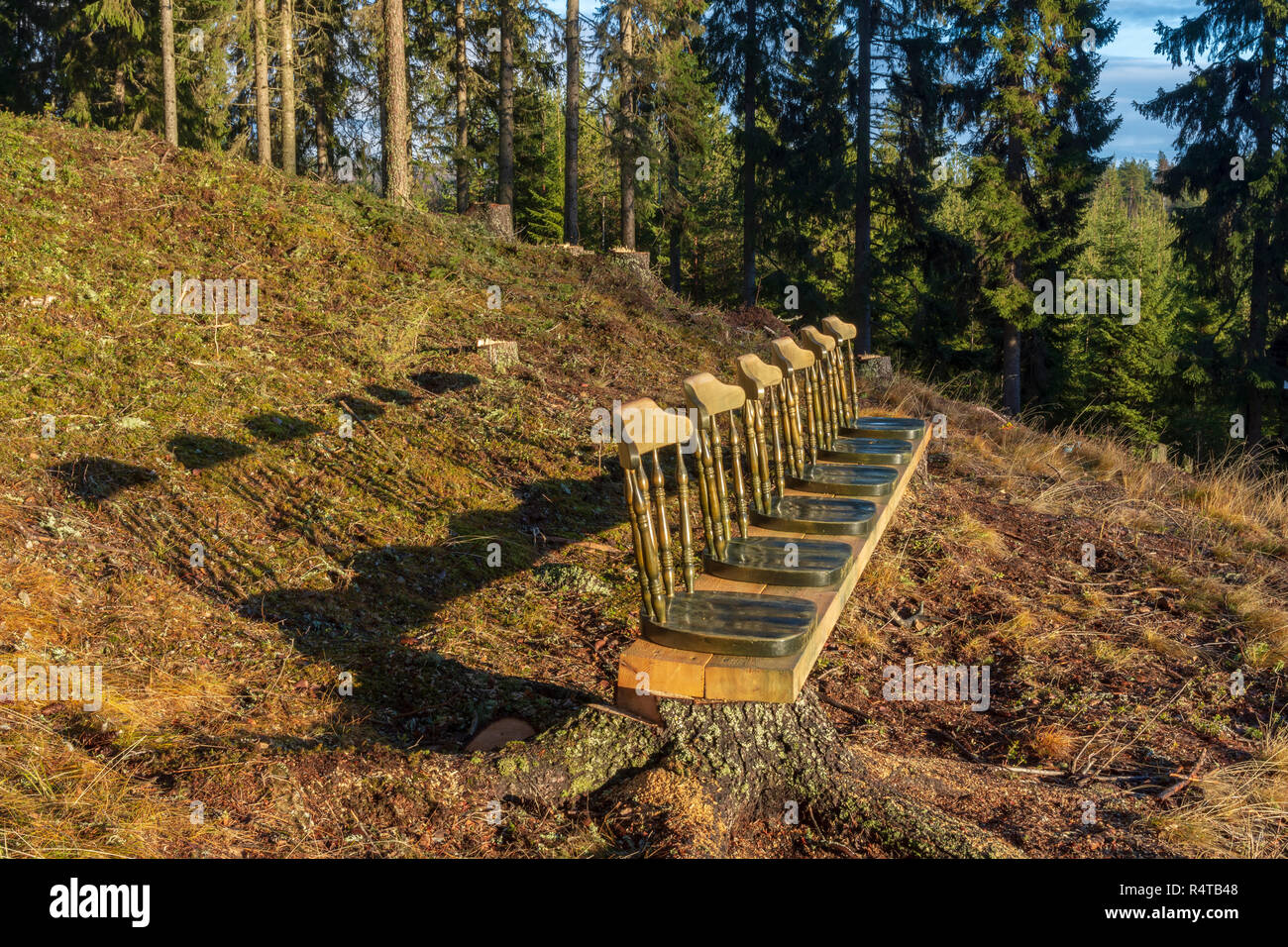 Sedia in un raw montata su una trave nel sole della sera con una foresta di sfondo, immagine dal nord della Svezia. Foto Stock