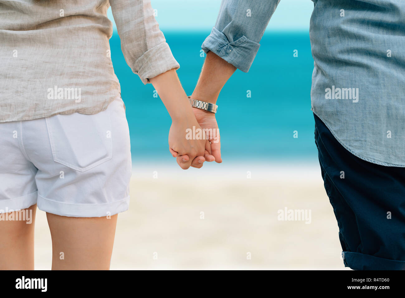Giovane tenendo le mani sulla spiaggia. Simbolo per l'amore. Foto Stock