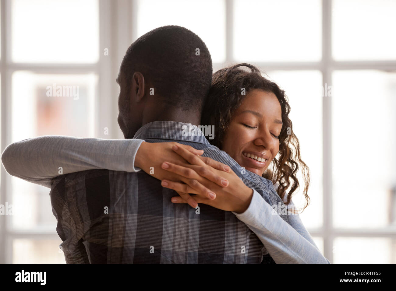 Attraente amorevole americano africano ragazza abbracciare fidanzato Foto Stock