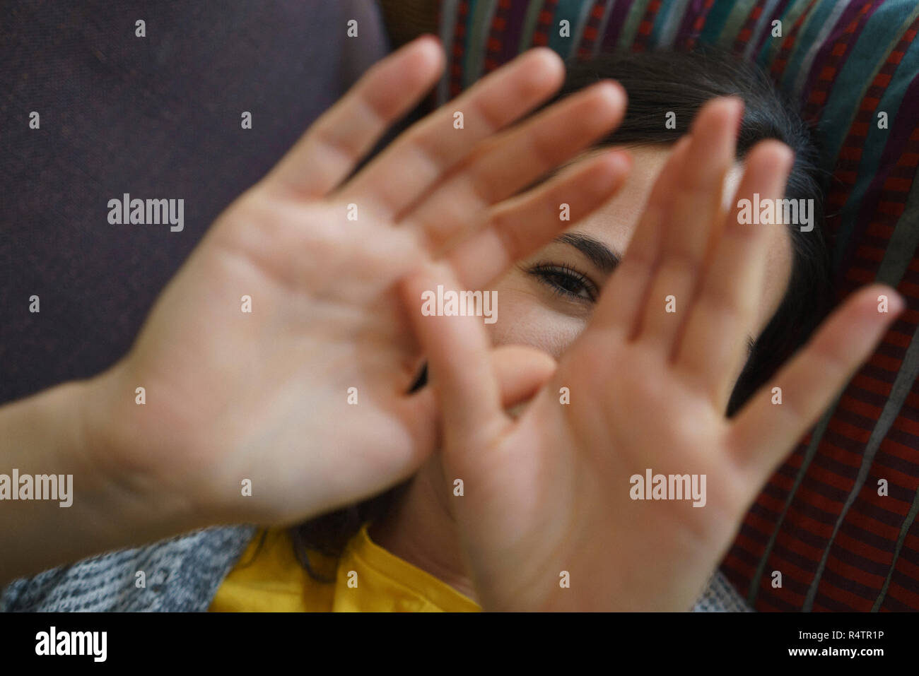 Ritratto di donna timida con le mani davanti al viso Foto Stock