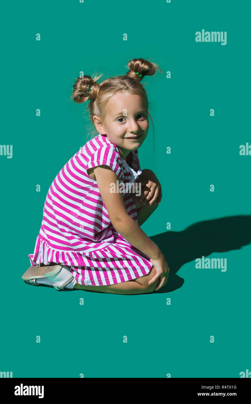 Ritratto ragazza sorridente contro lo sfondo di colore verde Foto Stock