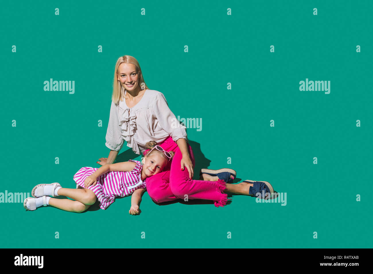 Ritratto di Madre e figlia rilassante su sfondo verde Foto Stock