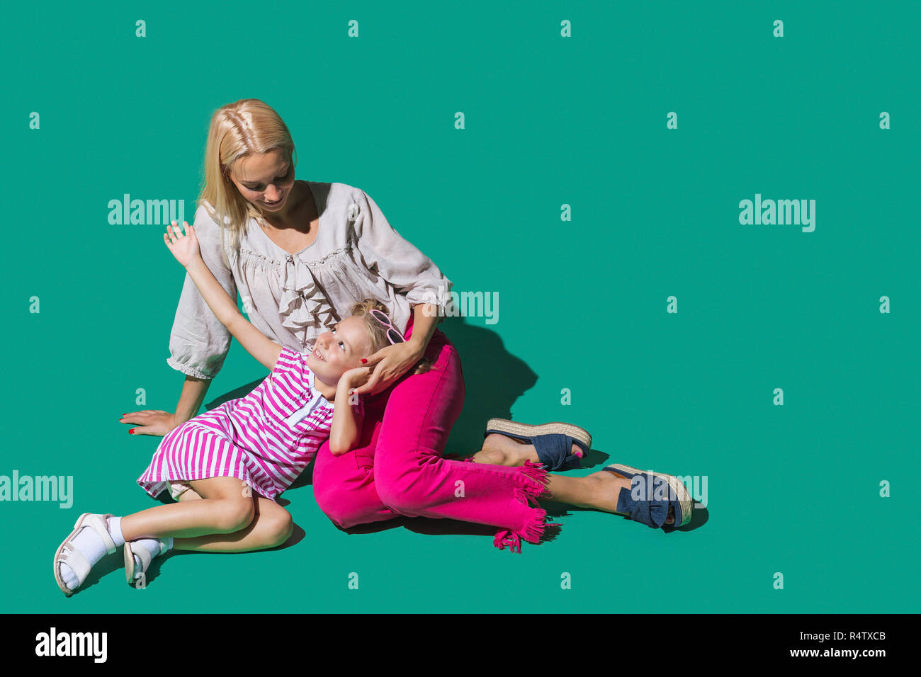 Madre e figlia di parlare contro lo sfondo di colore verde Foto Stock