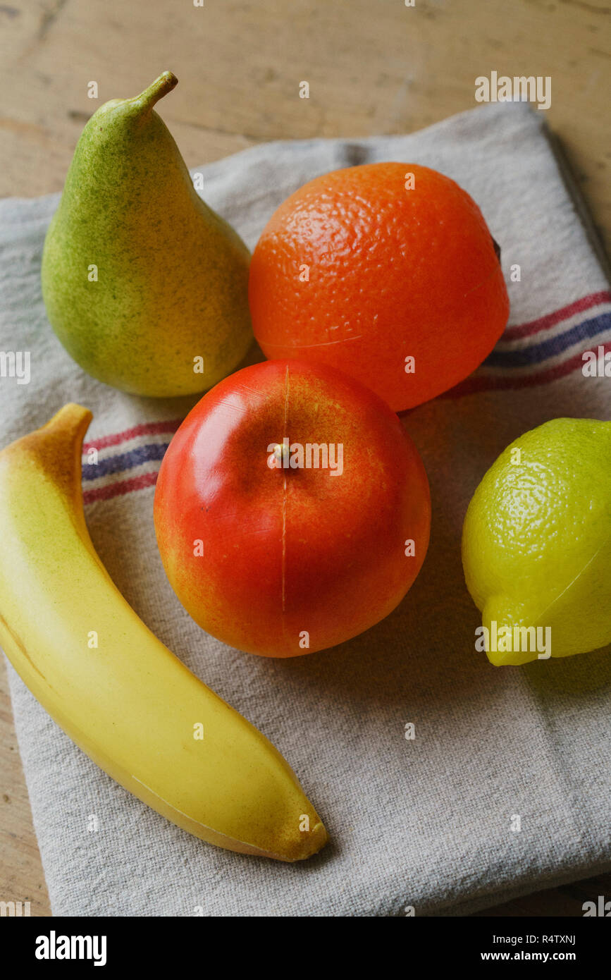 Frutti di plastica su asciugamano Foto Stock