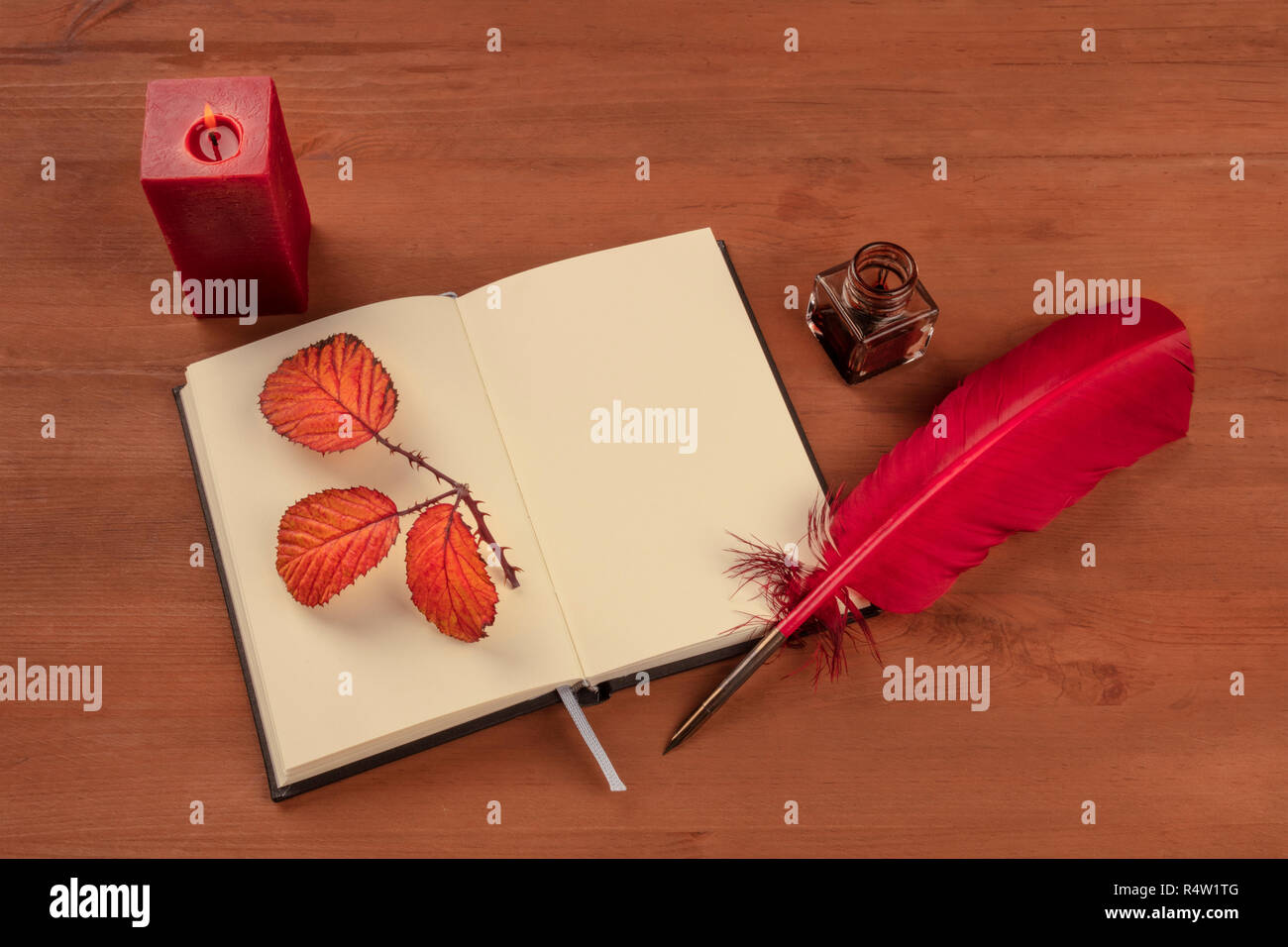 Poesia romantica. La foto di un cappello rosso con un inchiostro bene e un open journal su un sfondo di legno con colori intensi e di foglie di autunno, una candela accesa e copia Foto Stock