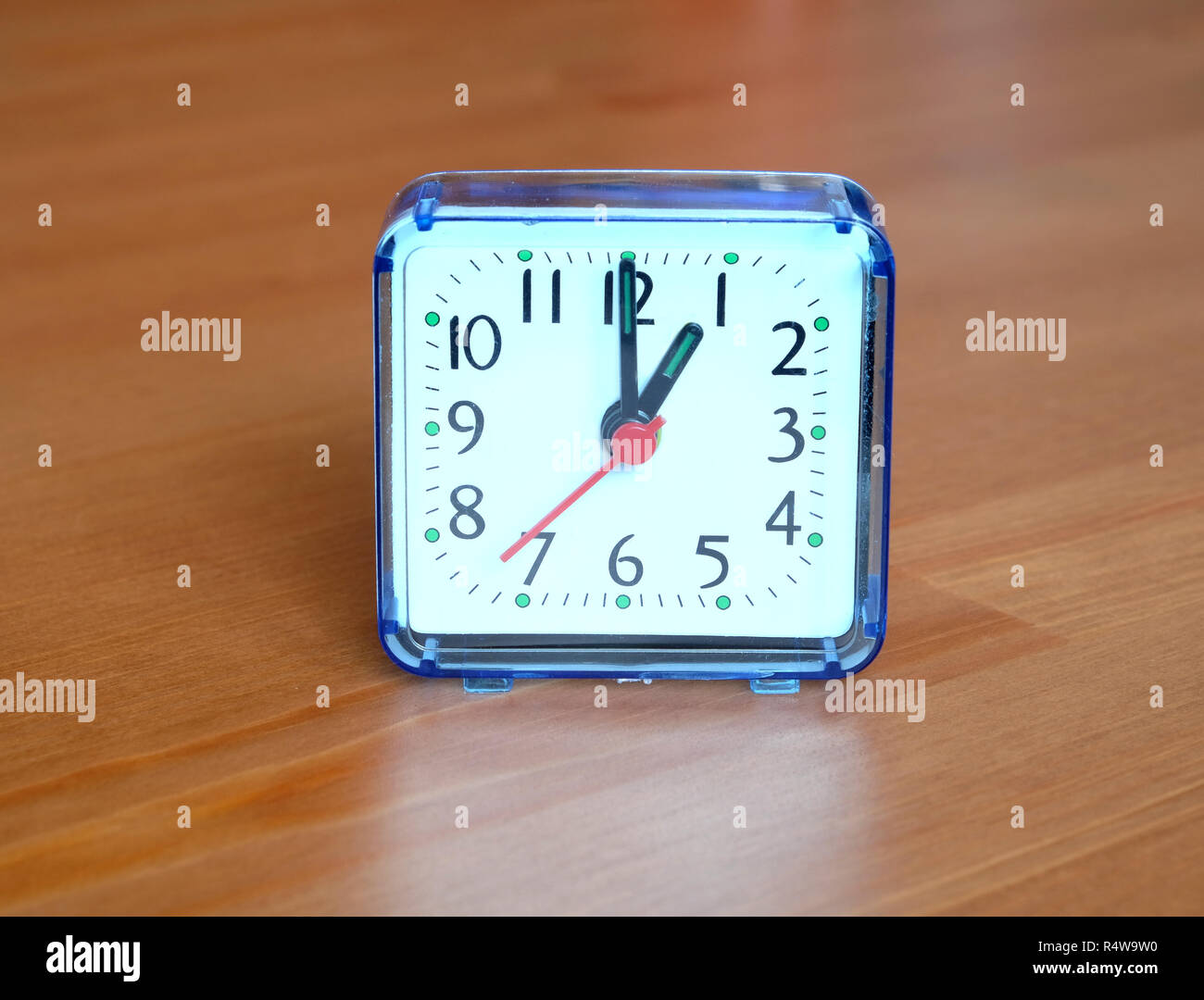 Orologio da tavolo forma quadrata che mostra uno o'clock su sfondo di legno closeup Foto Stock