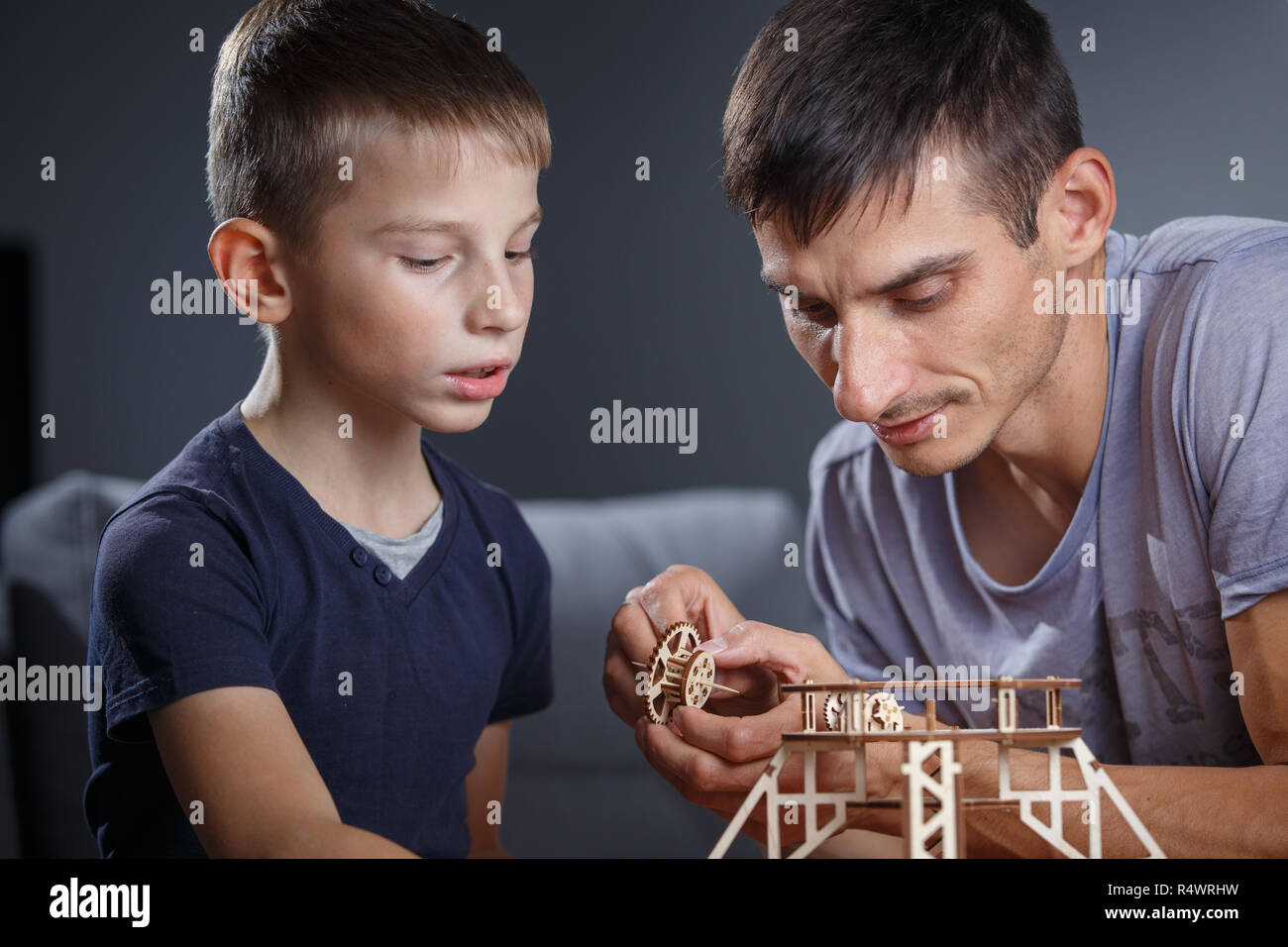 Ragazzo giovane assemblaggio costruttore di legno con suo padre. Edificio Eco giocattolo di cui Foto Stock