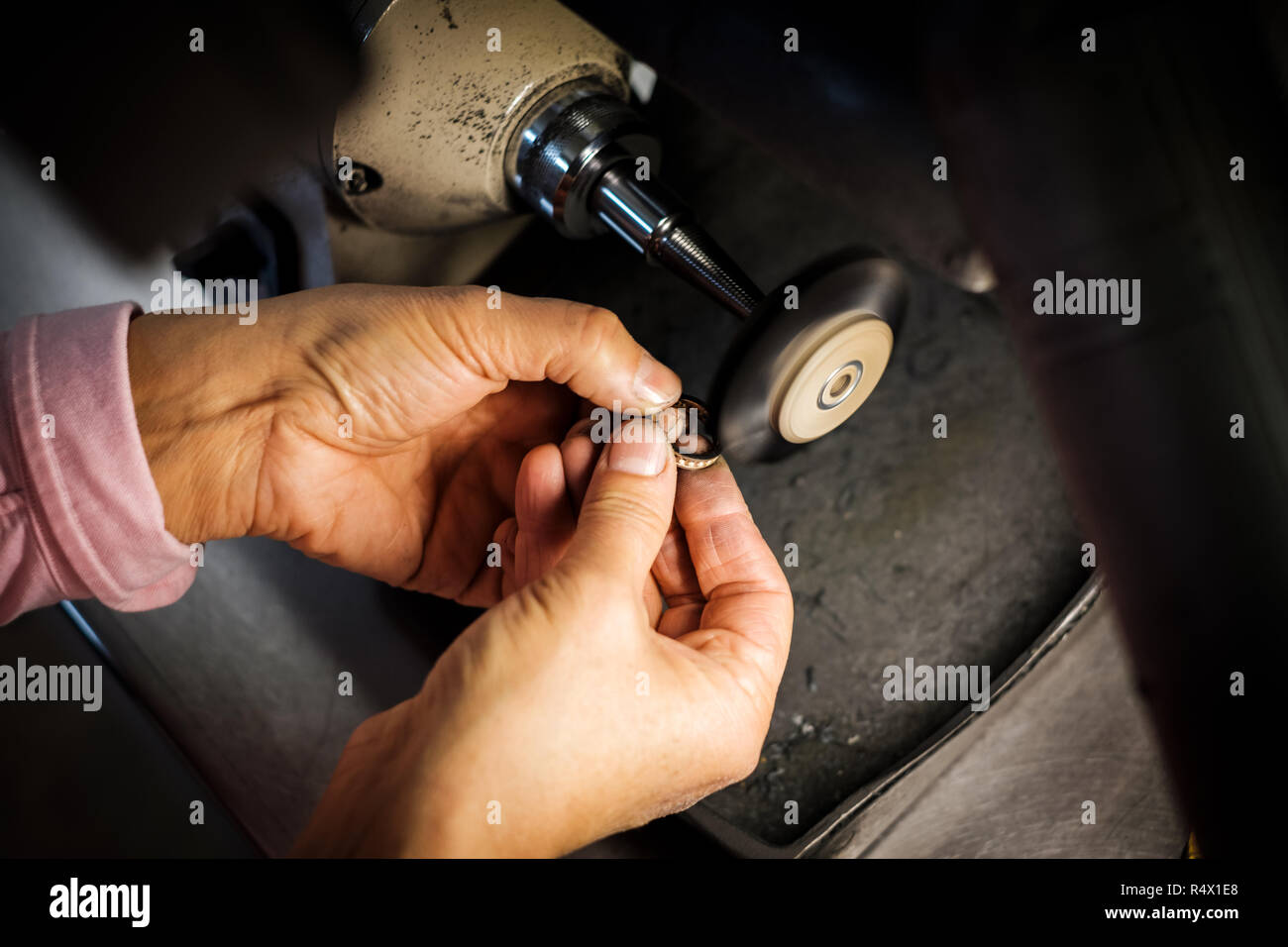 Gioielliere lucidi un anello d'oro su una smerigliatrice da banco in una autentica oreficeria workshop Foto Stock
