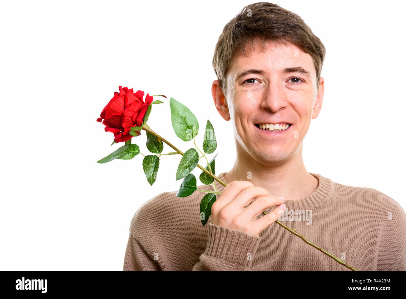 Close up di felice uomo sorridente mentre si tiene una rosa rossa Foto Stock
