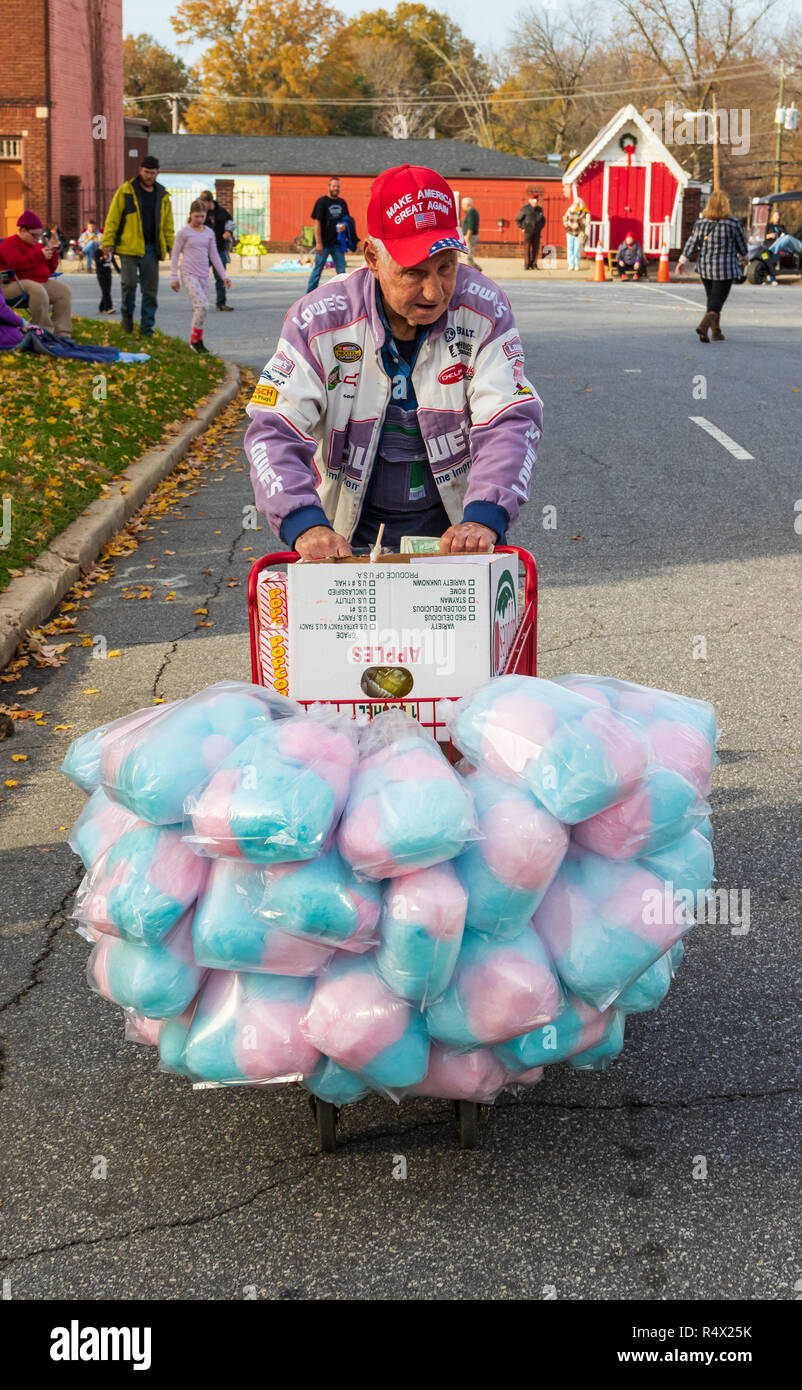 LINCOLNTON, NC, Stati Uniti d'America-11/25/18: uomo anziano spingendo un carrello riempito con cotone candy e confettura di mele. Foto Stock
