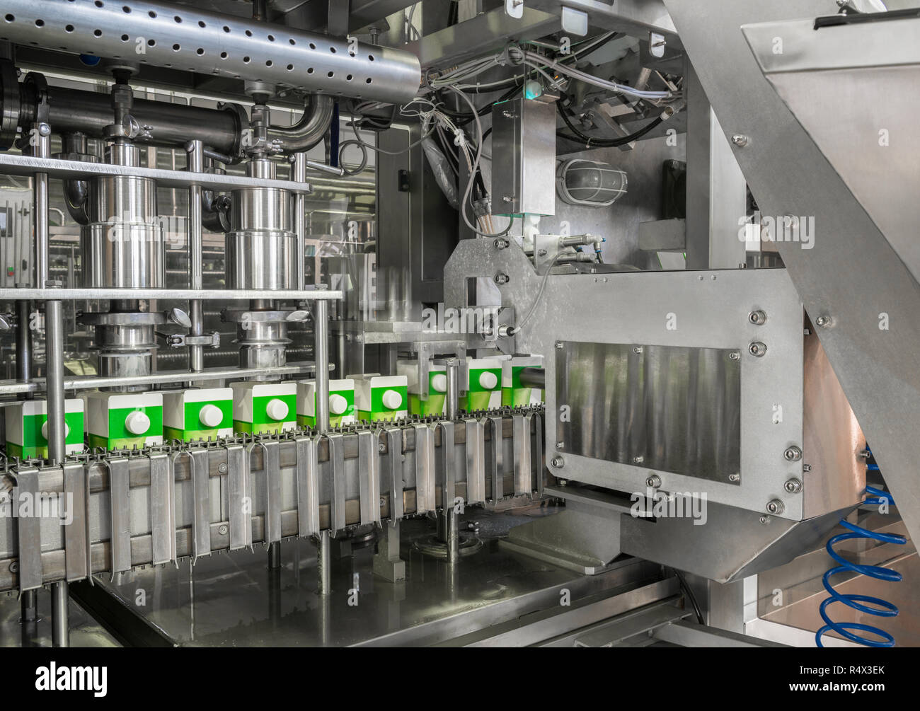 Il convogliatore di riempimento e confezionamento di bevande in contenitori di cartone. apparecchiature presso il caseificio Foto Stock