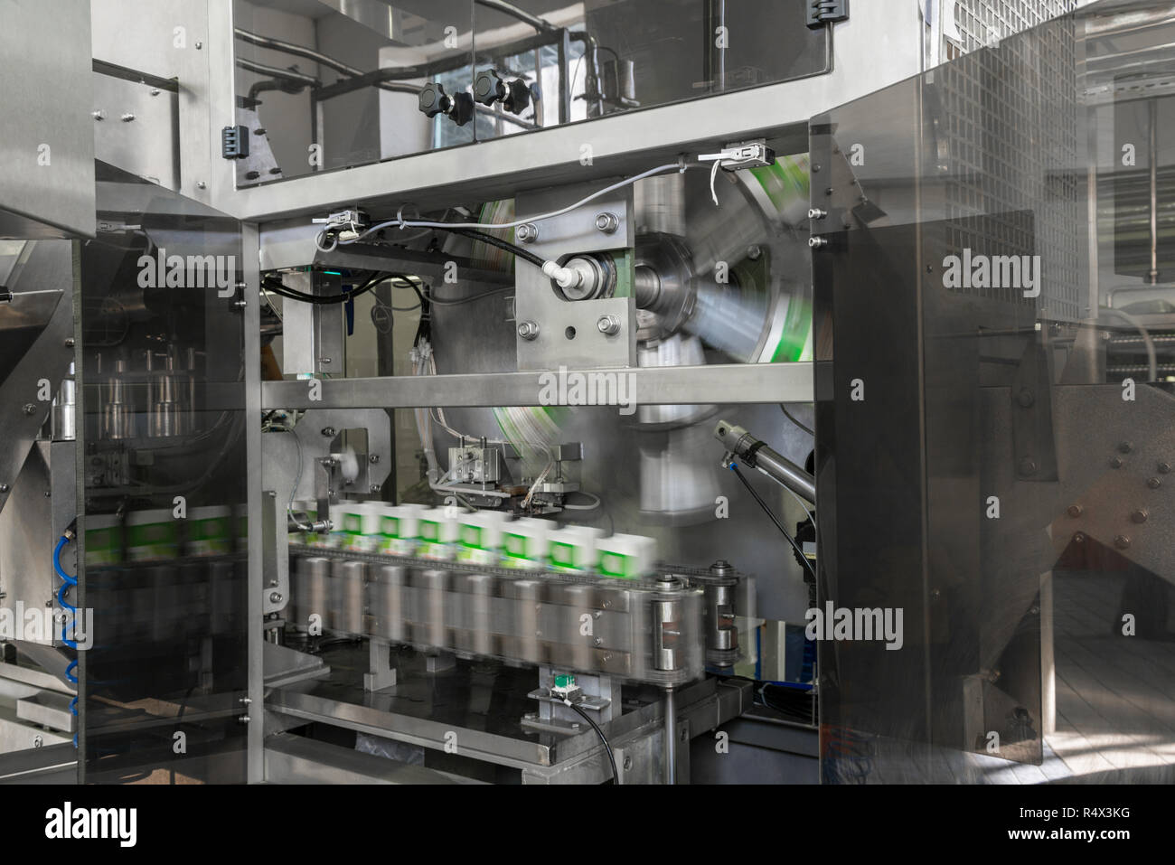 Il convogliatore di riempimento e confezionamento di bevande in contenitori di cartone. apparecchiature presso il caseificio Foto Stock
