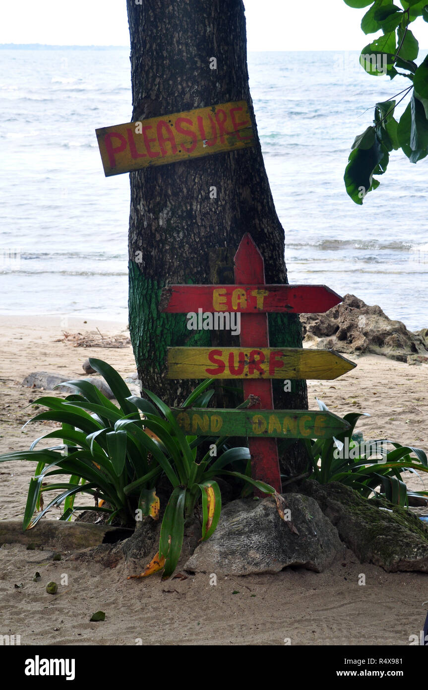 "Il piacere di mangiare Surf Dance' sui segni su un albero su di una spiaggia Foto Stock