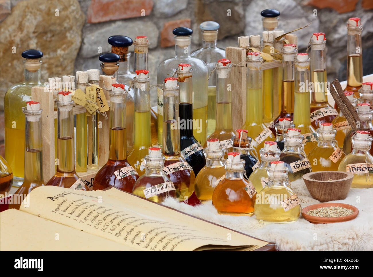 Bottiglie e brocche contenenti bevande realizzate con ricette tradizionali a un festival italiano Foto Stock
