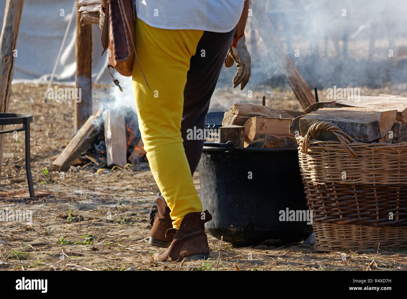 Close-up di un uomo nel borgo medievale di nero e pantaloni gialli è addensarsi il fuoco ad una rievocazione Foto Stock