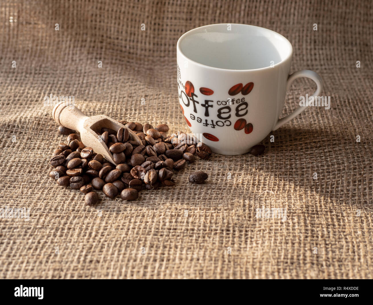 Tazza di caffè e fagioli su tela sacco Foto Stock