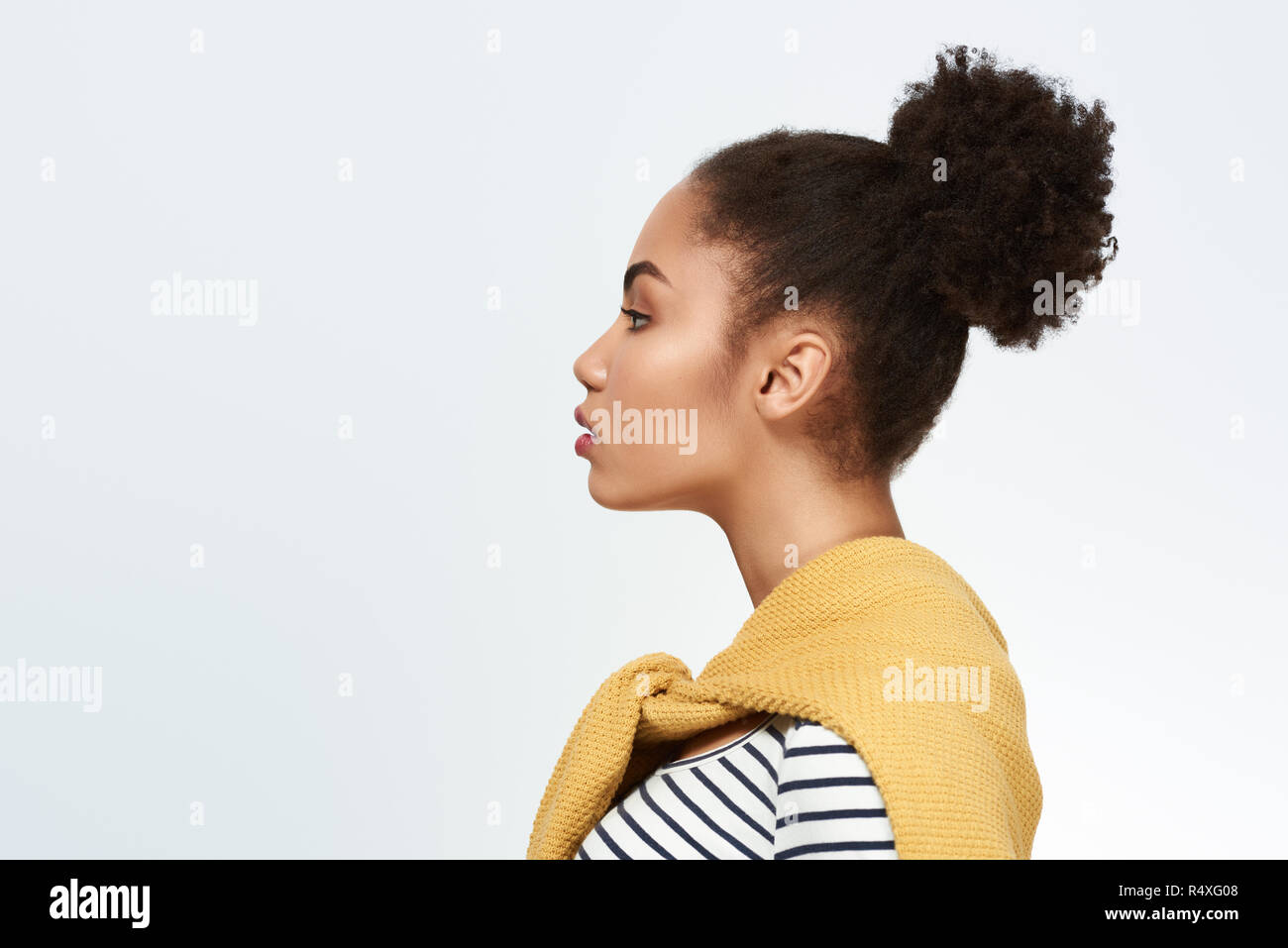 Giovane donna studio isolato in bianco di toccare la faccia cercando camer Foto Stock