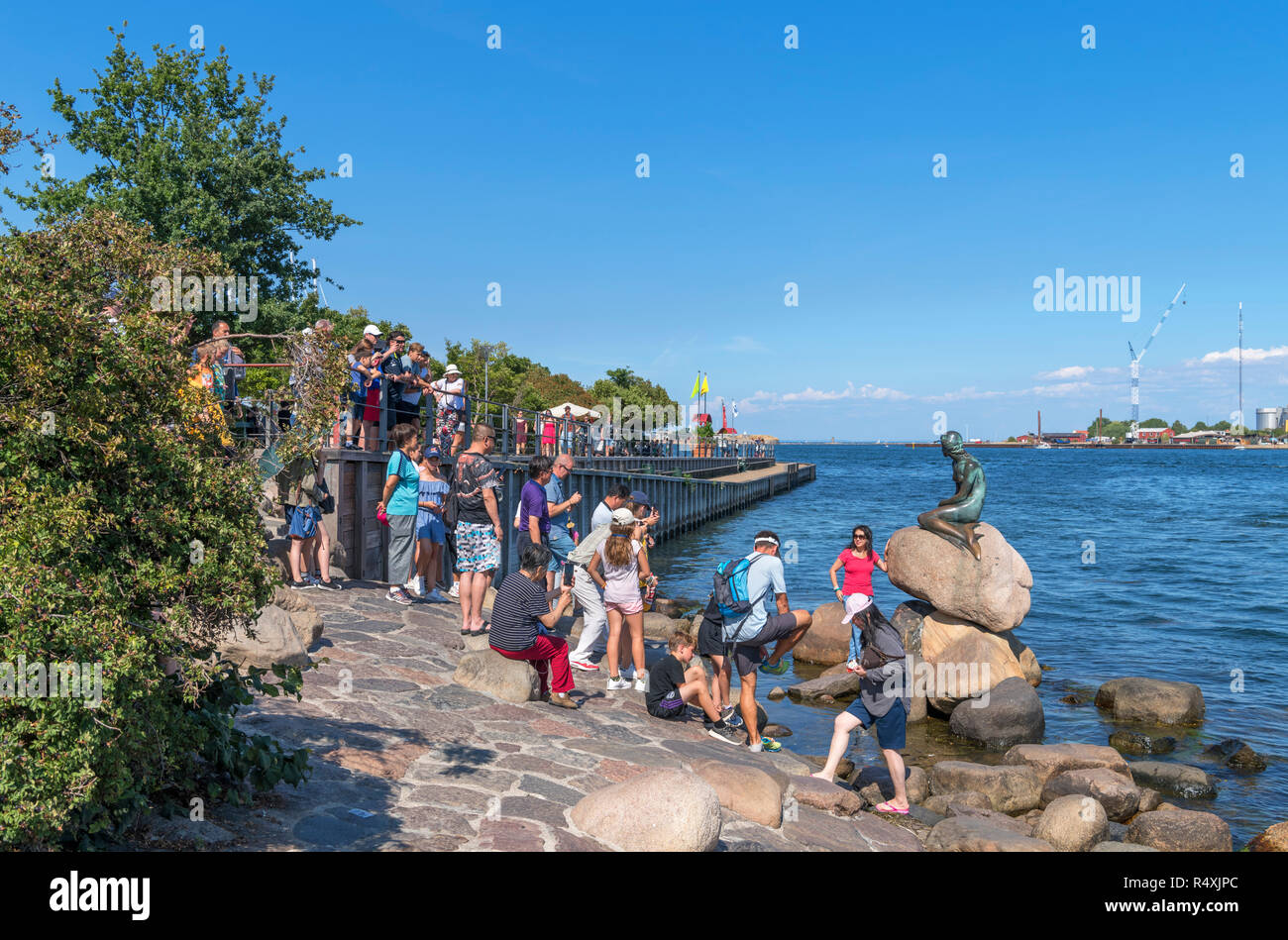 I turisti che posano per una foto dalla Sirenetta (Den lille havfrue), Copenhagen, Danimarca Foto Stock