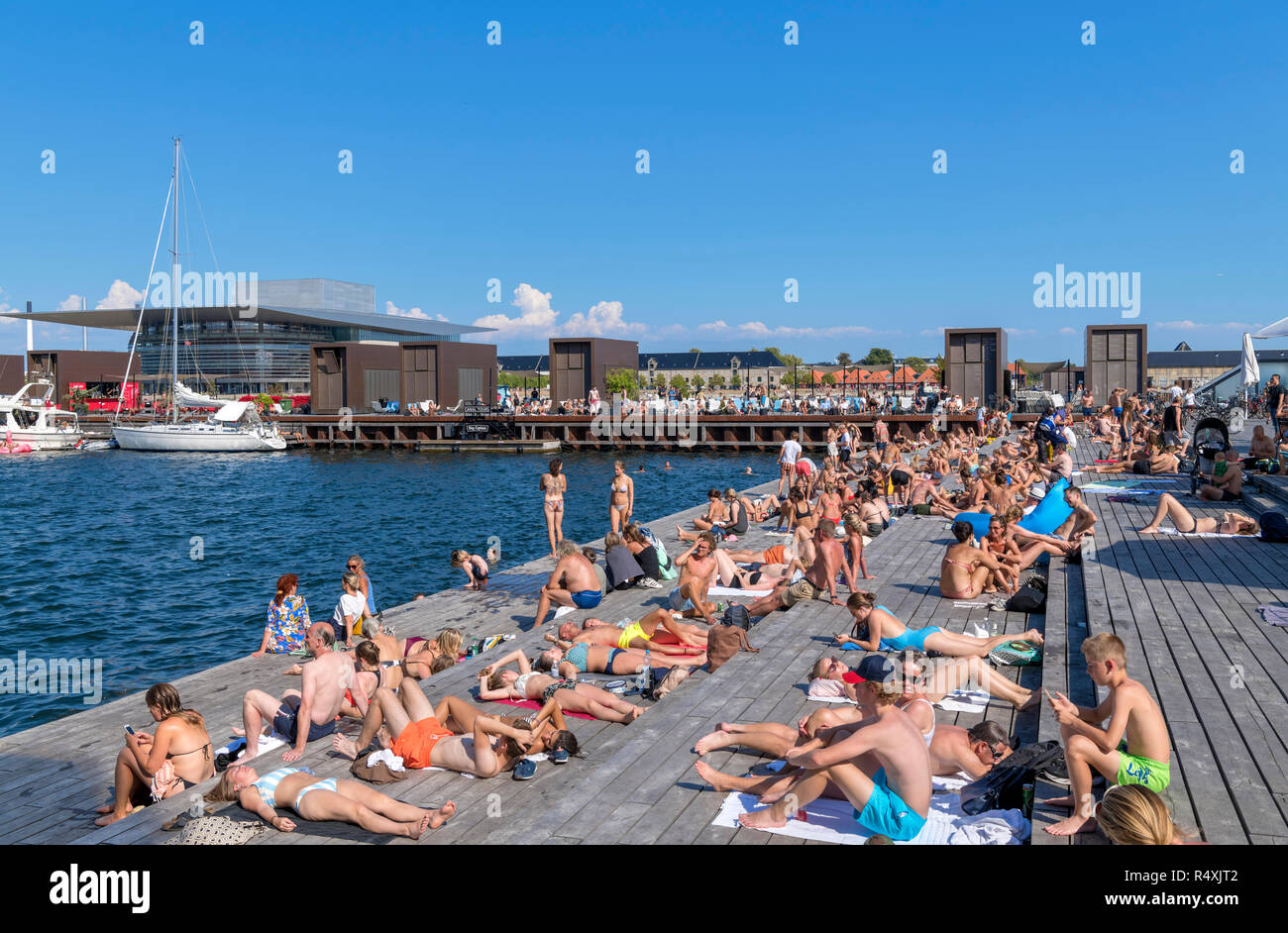 La gente a prendere il sole a Kvaesthusgraven, quartiere di Nyhavn, Copenhagen, Danimarca Foto Stock