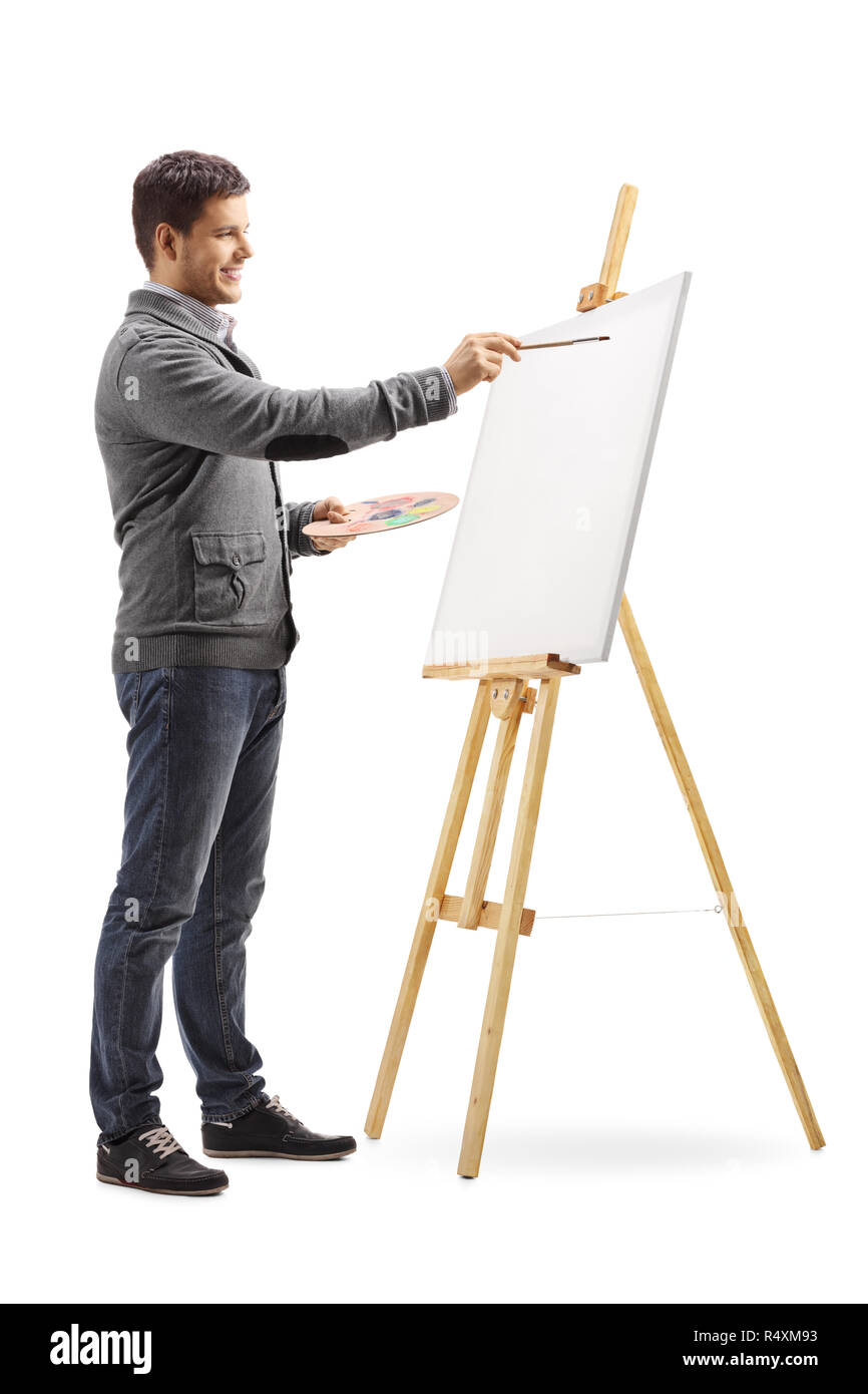 A piena lunghezza shot di un sorridente giovane pittura su una tela di canapa isolati su sfondo bianco Foto Stock