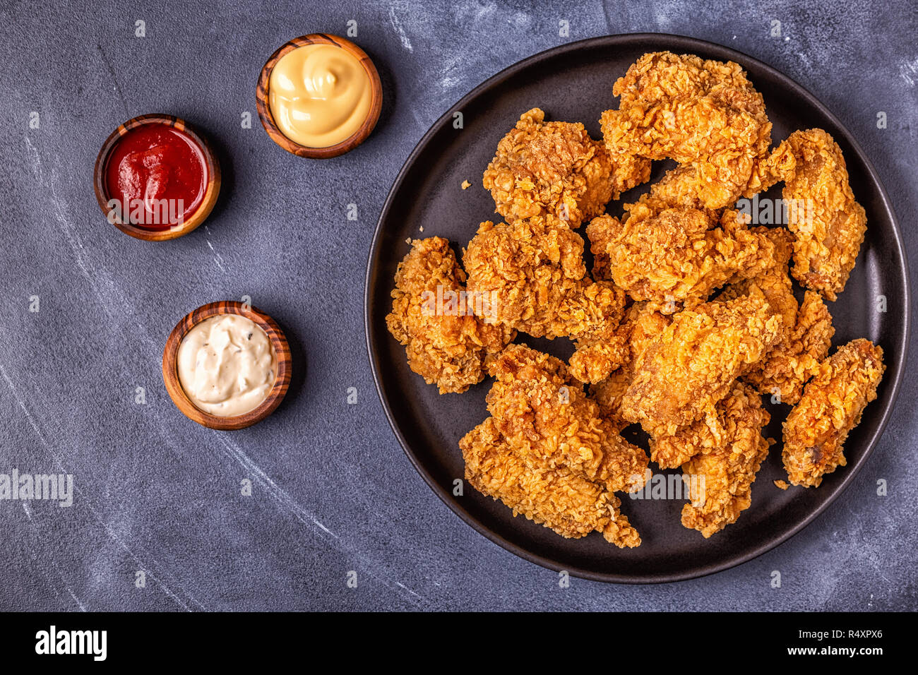 Alette di pollo fritte con salse varie, vista dall'alto. Foto Stock