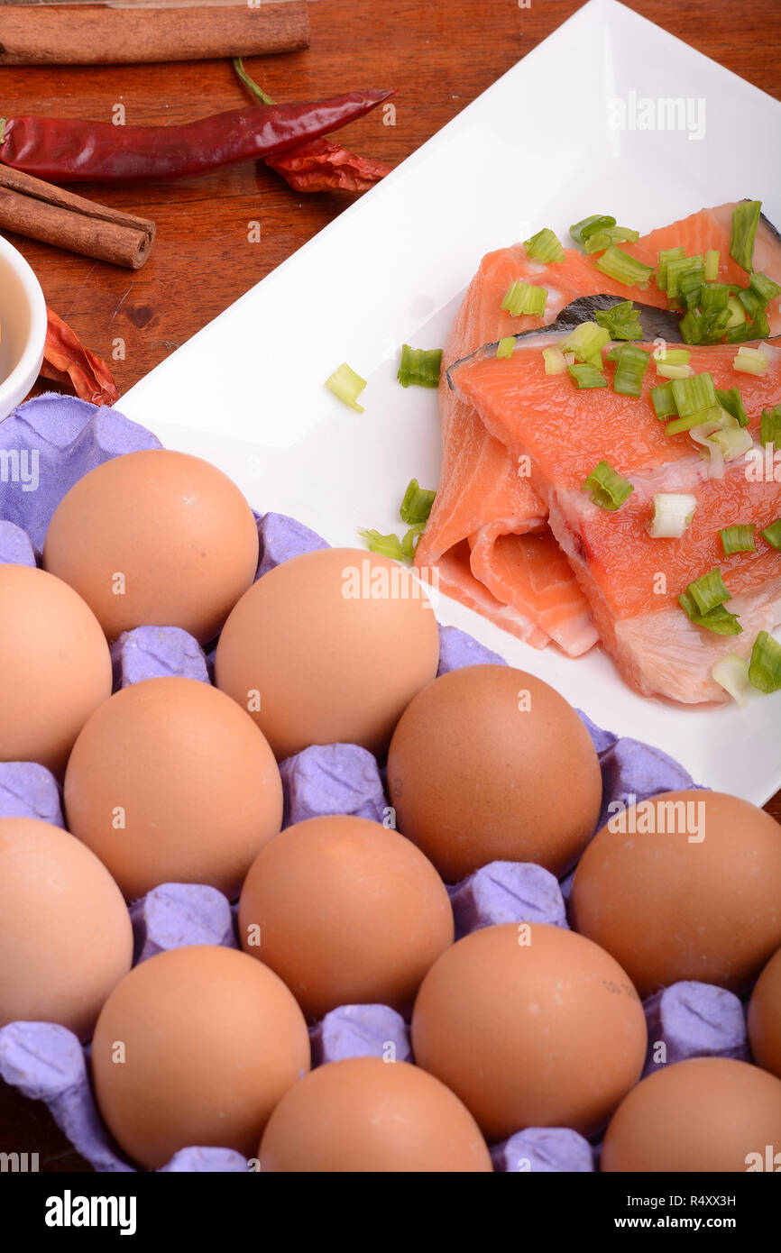 Di filetto di salmone fresco vicino fino sulla piastra bianca. pepe rosso, uova e limone Foto Stock