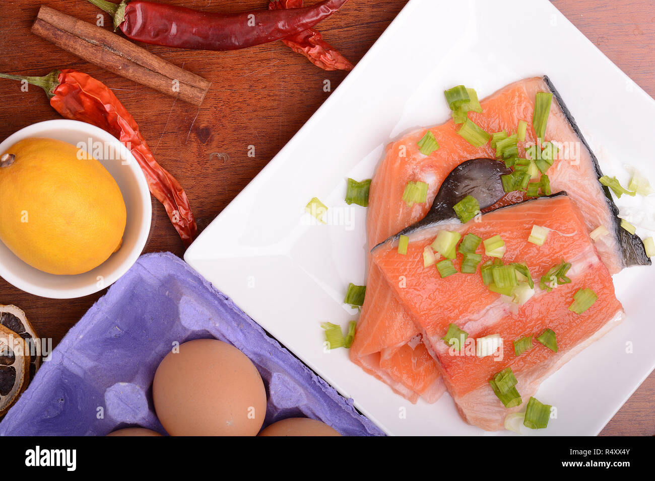 Di filetto di salmone fresco sulla piastra bianca. rosso pepe, cannella e limone Foto Stock