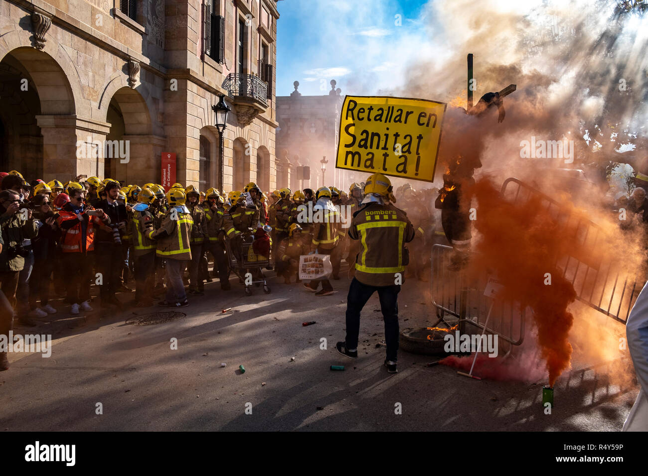 Un vigile del fuoco è visto con una targhetta prima di masterizzarlo durante la protesta. Centinaia di vigili del fuoco sono stati riuniti davanti al Parlamento della Catalogna a pressione le trattative salariali e la domanda di assunzione di più i vigili del fuoco e il rinnovo del materiale da lavorare. Foto Stock