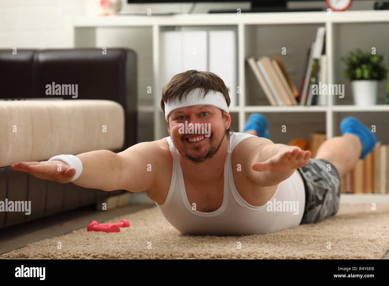 Giovani attraenti uomo fitness giace su un tappeto di grasso con Foto Stock