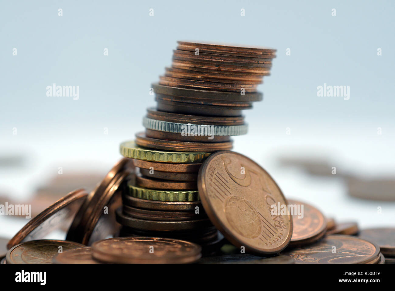 Pila di monete a sfondo bianco Foto Stock
