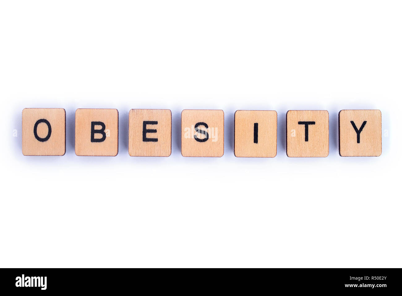 La parola obesità, farro con lettera in legno piastrelle Scrabble. Foto Stock