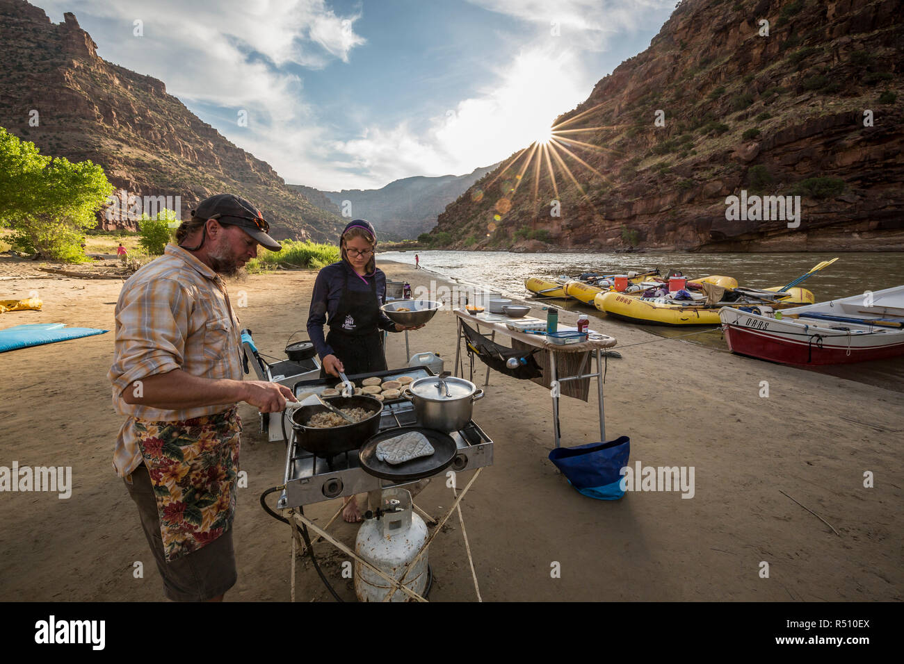 Due guide rafting cucinare un pasto presso il camp mentre su un Green River Rafting Trip desolazione/Grigio sezione del canyon, Utah, Stati Uniti d'America Foto Stock