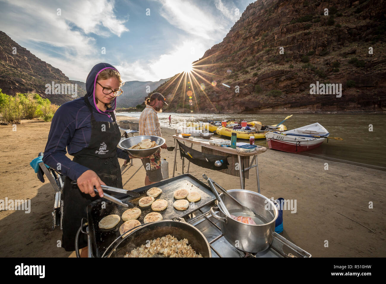 Due guide rafting cucinare un pasto presso il camp mentre su un Green River Rafting Trip Â desolazione/GrayÂ Canyon sezione, Utah, Stati Uniti d'America Foto Stock