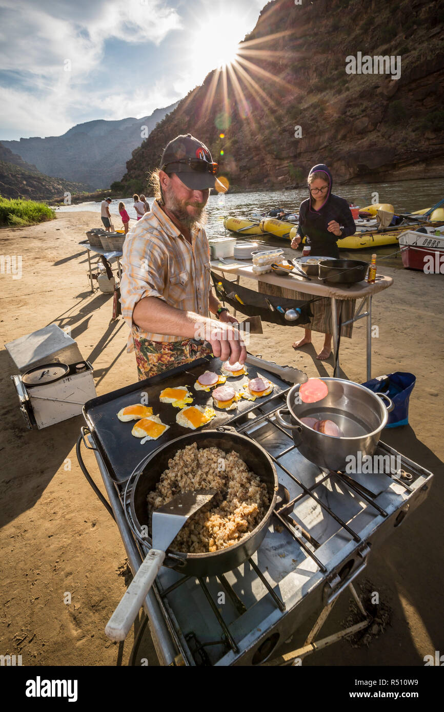 Due guide rafting cucinare un pasto presso il camp mentre su un Green River Rafting Trip Â desolazione/GrayÂ Canyon sezione, Utah, Stati Uniti d'America Foto Stock