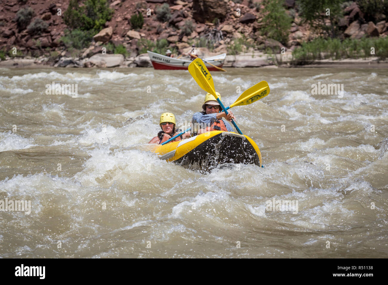 Un uomo e una donna paddling anÂ inflatableÂ kayak attraverso le rapide su un Green River Rafting Trip Â desolazione/GrayÂ Canyon sezione, Utah, Stati Uniti d'America Foto Stock