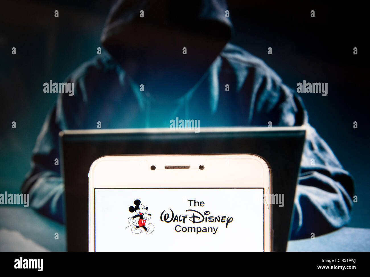 Multinazionale Americana mass media e intrattenimento il Walt Disney  Company o anche chiamato logo Disney è visto su un androide dispositivo  mobile con una figura di hacker in background Foto stock -