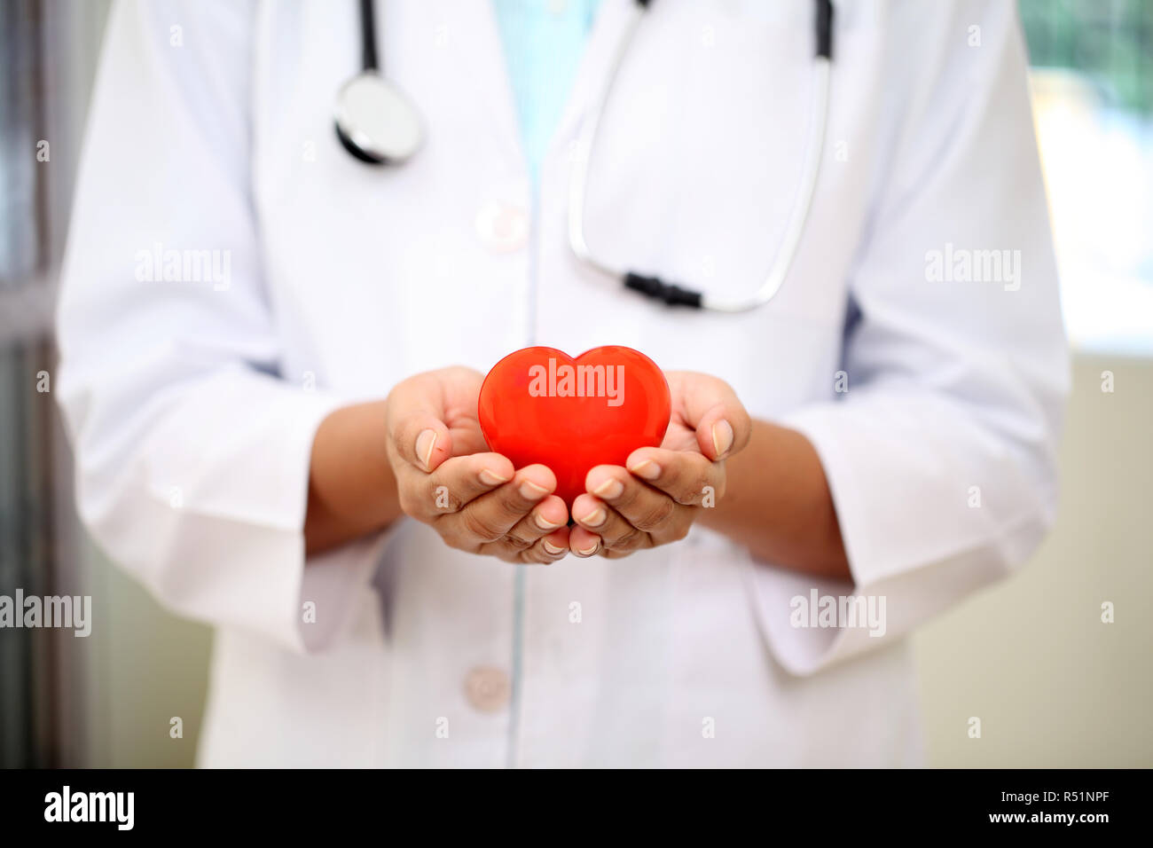 Medico donna tenendo un bel rosso forma di cuore Foto Stock