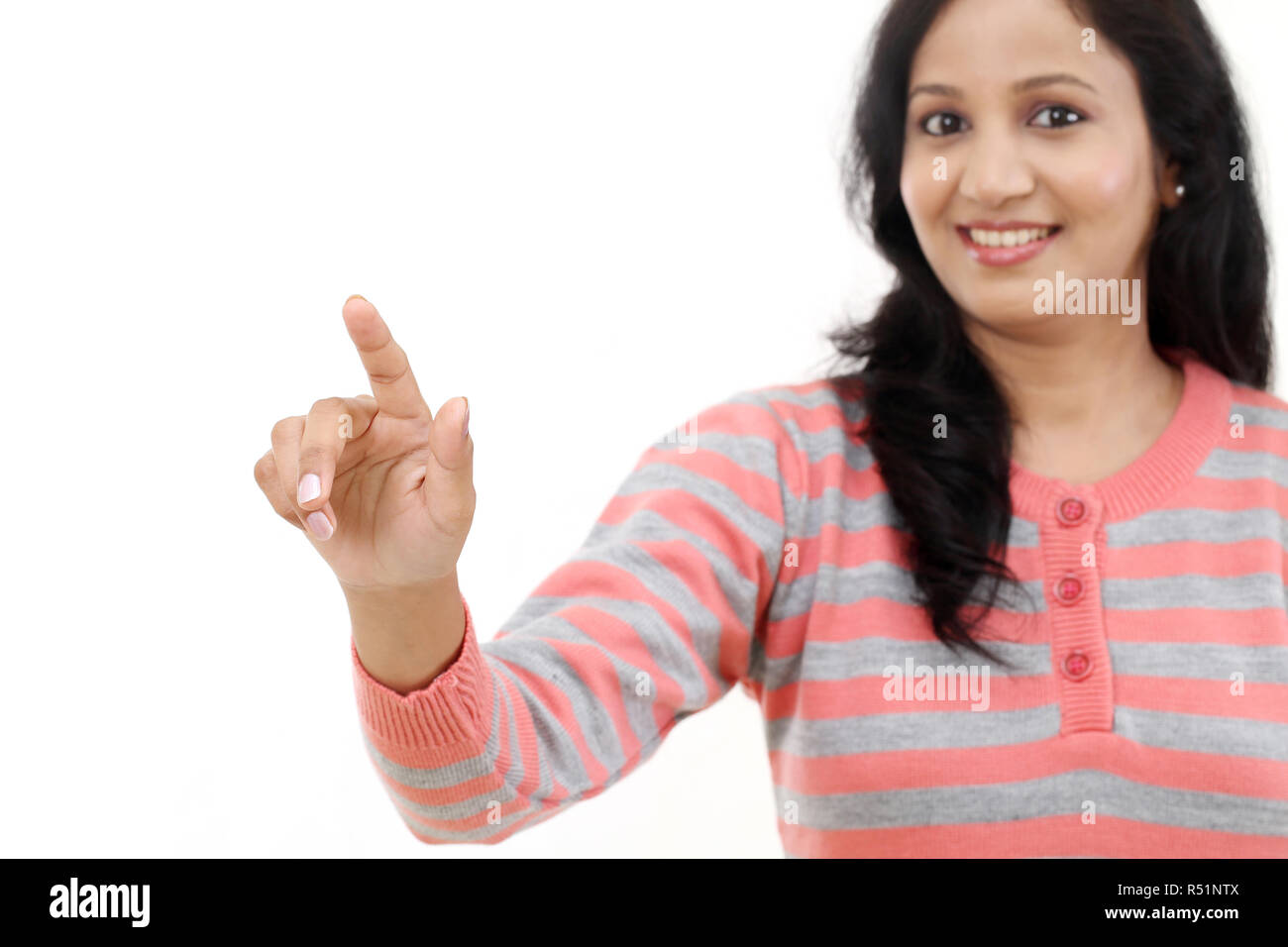 Sorridente giovane donna immaginaria di toccare lo schermo con il dito Foto Stock