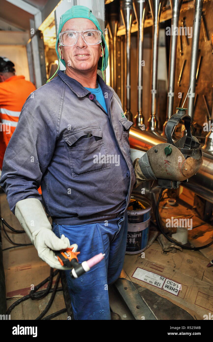 Italiano (da Venezia) ASME saldatori certificati facendo un lavoro preciso a idrogeno di trattamento e di unità di produzione in KazMunaiGaz 110,000b/d di raffineria di Atyrau. Foto Stock